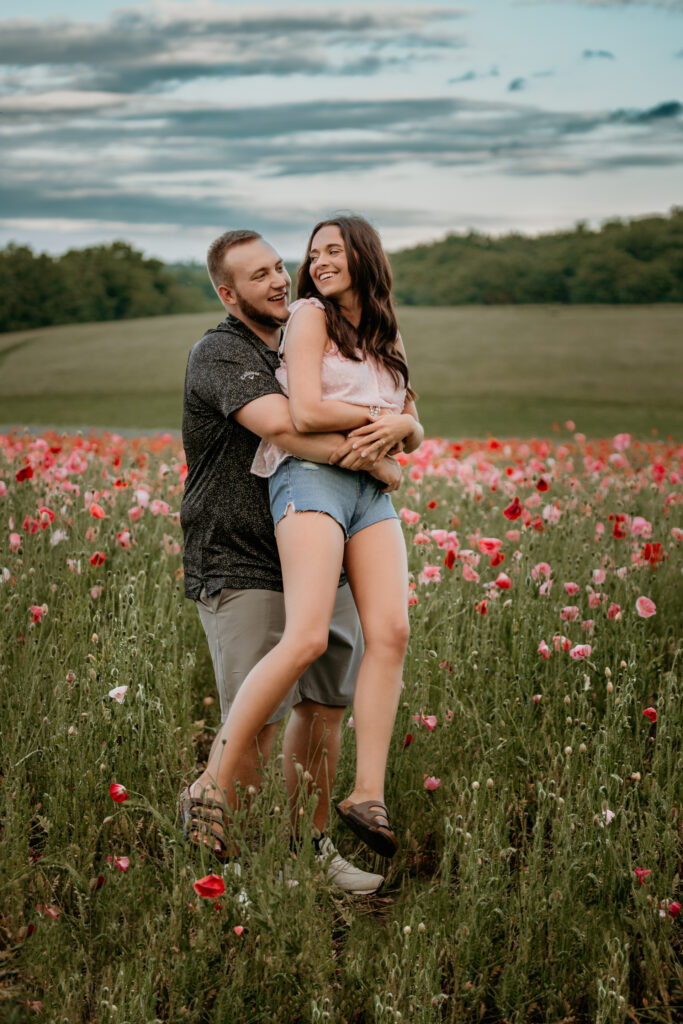 A couple in love embracing in a sunlit flower field at Middle Springs Farm, captured by Winchester Kentucky Photographers A Pair of Perry's Photography.